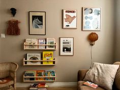 a living room with bookshelves and pictures on the wall above it's couch