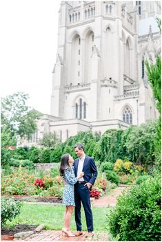 an engaged couple standing in front of a castle