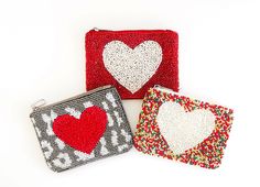 three purses with hearts on them sitting next to each other