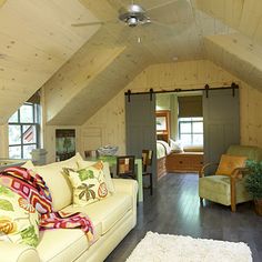 a living room filled with furniture next to a wooden floor covered in white rugs