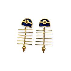 two pairs of gold and blue earrings with spikes on them, one in the shape of an eye