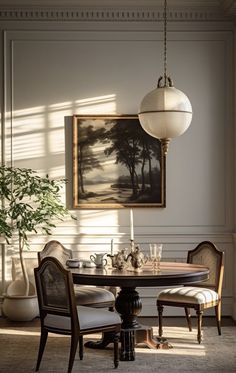 a dining room table with chairs and a painting on the wall