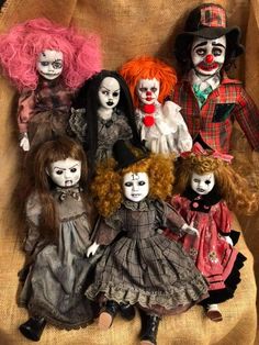 a group of creepy dolls sitting on top of a brown cloth covered chair with red hair