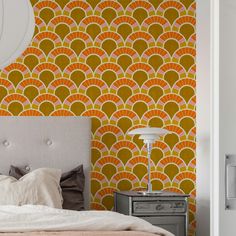 an orange and yellow wallpaper in a bedroom with a large headboard on the bed