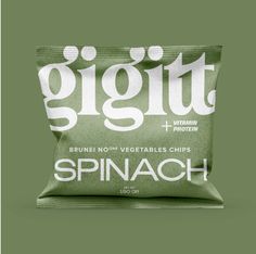 a bag of spinach chips sitting on top of a green surface with white lettering