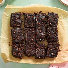 chocolate brownies cut into squares on top of parchment paper