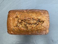 a close up of a loaf of bread on a gray surface with a blue background