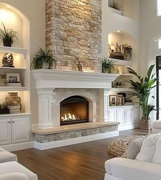 a living room with white furniture and a fireplace