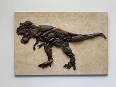 a sculpture of a dinosaur made out of rocks on a white wall in a room