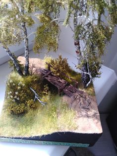 an image of a miniature model of a bridge in the woods with trees on it