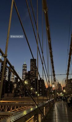 the city skyline is lit up at night as seen from a bridge in new york