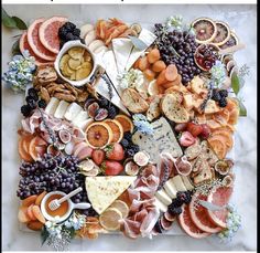 an assortment of cheeses, fruits and meats on a platter with text overlay