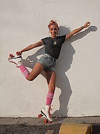 a young woman riding a skateboard down the side of a road