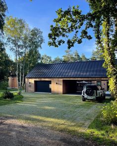 a truck is parked in front of a building with a metal roof and two garages