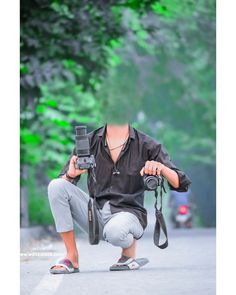 a man kneeling down holding a camera and taking a picture with his hands on the ground