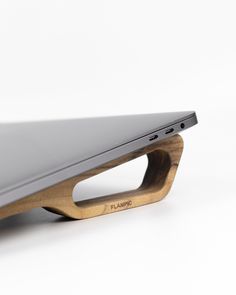 a laptop computer sitting on top of a wooden stand