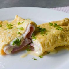 an omelet with ham and cheese on a white plate