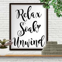 a white brick wall with a black and white sign that says relax soak unwind