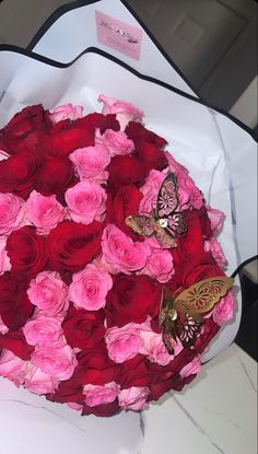 a bouquet of roses with butterflies on it