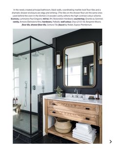 the bathroom is decorated in black and white with gold accents, including a large mirror