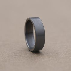 a wedding ring is sitting on the ground in front of a gray background with no one around it