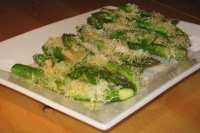 a white plate topped with green vegetables on top of a wooden table