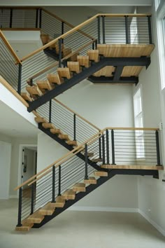 an open staircase with wooden handrails and metal railing in a large white room