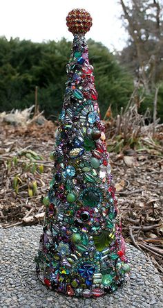 a glass christmas tree sitting on top of a rock