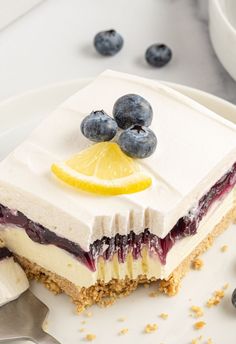 a piece of cake with blueberries and lemon on top