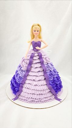 a barbie doll cake with purple and lavender ruffles