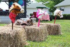 three horse heads are placed on hay bales