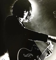 black and white photograph of a man playing an electric guitar