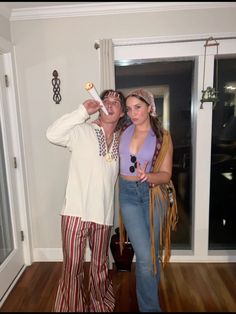 a man and woman standing in front of a door with food on their fingers, posing for the camera