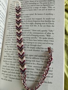 an open book with a bracelet on top of it