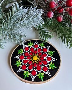 a decorated christmas ornament sitting on top of a table next to evergreen branches