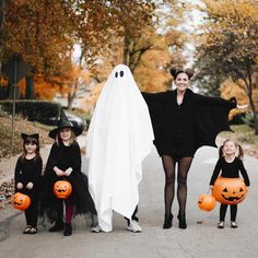 a woman and two children dressed up in halloween costumes