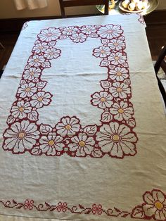 an embroidered table cloth with flowers on it