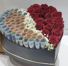 a large heart shaped box filled with lots of roses and baby's breath rolls