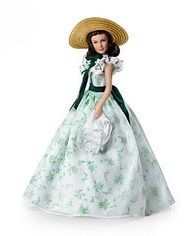 a doll wearing a green and white dress with a straw hat on top of her head