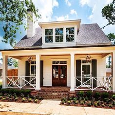 a white house with black shutters on the front porch