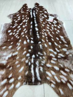 a brown and white deer skin rug on the floor