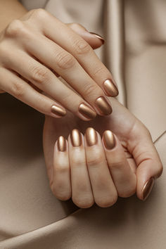 an image of a hand with bronze nail polish