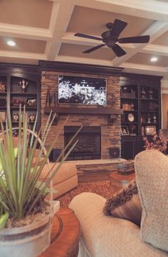 a living room filled with furniture and a flat screen tv mounted on the wall above a fireplace