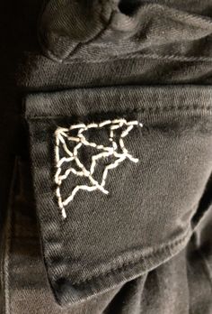 the back pocket of a pair of black jeans with white stitching on it and a small patch in the pocket