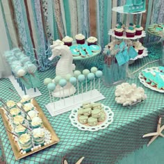 an ocean themed dessert table with cupcakes and cookies on it's sides