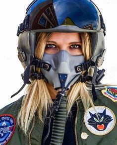 a woman wearing an air force pilot's helmet and goggles with patches on her face