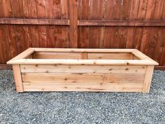 a large wooden planter sitting on top of gravel