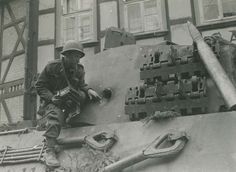 a man sitting on top of a tank in front of a building