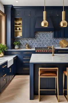 a kitchen with blue cabinets and gold pendant lights hanging from the ceiling over the island