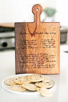 a wooden cutting board sitting on top of a table next to crackers and a plate